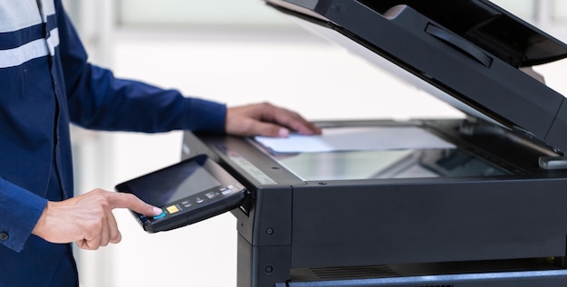 Homme d'affaires, appuyez sur le bouton sur le panneau du réseau de photocopieurs de l'imprimante Travailler sur des photocopies dans le concept de bureau L'imprimante est un équipement d'outil d'employé de bureau pour la numérisation et la copie de papier