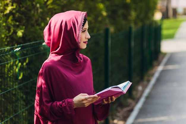 Homme d'affaires arabe confiant souriant et promenades de dubaï affaires arabes vumen hijab est dans les rues contre les gratte-ciel de dubaï la femme est vêtue d'une abaya noire