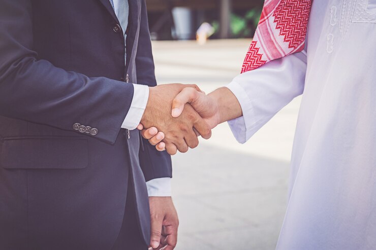 Homme d'affaires arabe donnant une poignée de main à son partenaire, sur un chantier de construction