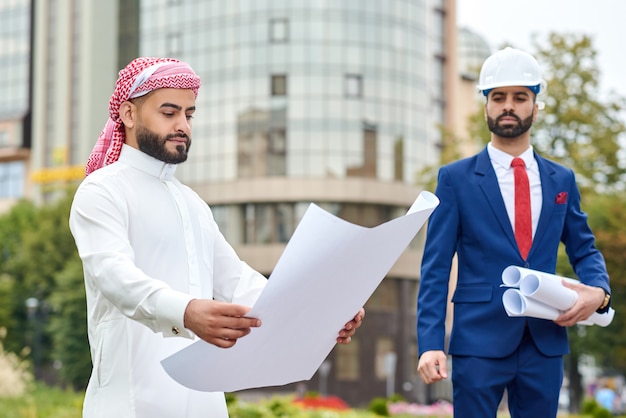 Homme d'affaires arabe examinant le plan de développement architectural