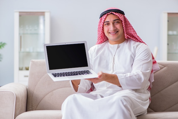 Homme d'affaires arabe travaillant assis sur un canapé