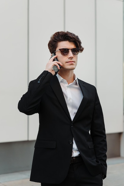 Homme d'affaires argentin en lunettes de soleil parlant au téléphone