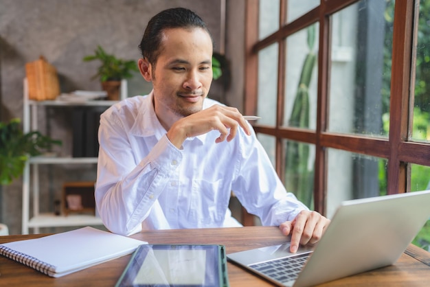 Photo homme d'affaires asiatique homme d'affaires indépendant travaillant dans un espace de coworking ou un café