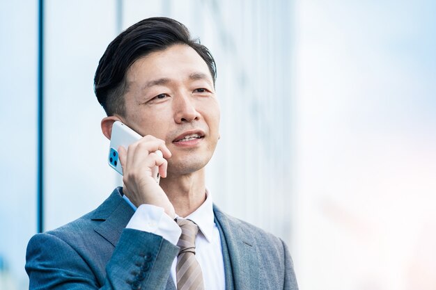 Homme d'affaires asiatique parlant sur un smartphone