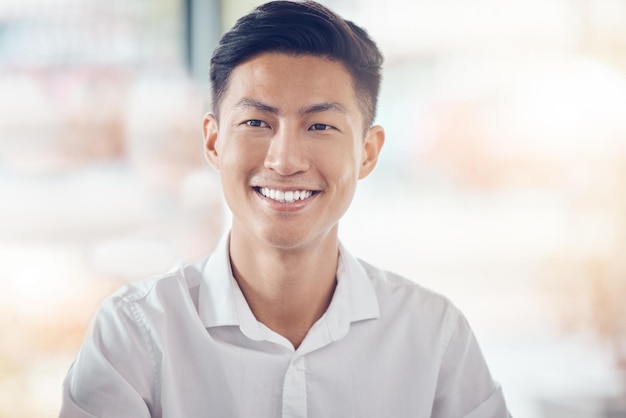 Un homme d'affaires asiatique et un portrait sourient avec une vision heureuse du succès sur un fond de bokeh Un homme japonais prospère souriant avec des dents dans le bonheur pour une idée de plan d'entreprise ou un objectif au bureau