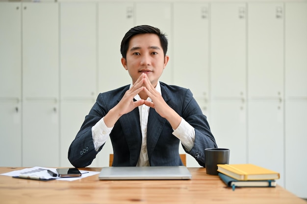 Homme d'affaires asiatique professionnel et intelligent est assis à son bureau