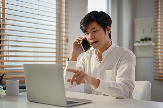 Homme d'affaires asiatique prospère ayant un appel téléphonique formel avec son partenaire commercial