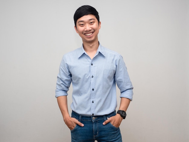 Homme d'affaires asiatique souriant main dans la poche de jeans portrait en studio