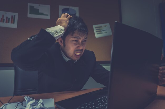 Homme d'affaires asiatique stressé en raison d'un travail excessifSe sentir épuisé