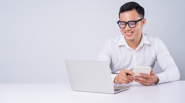 Homme d'affaires asiatique utilisant un ordinateur portable sur blanc