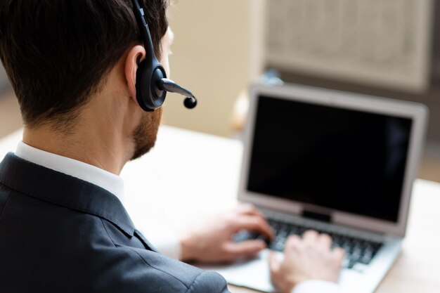 Homme d'affaires assis au bureau de l'ordinateur au bureau et participant à une vidéoconférence