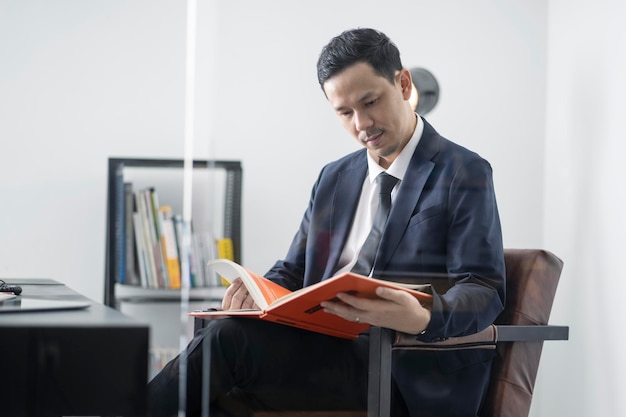 Homme d'affaires assis au bureau en train de lire