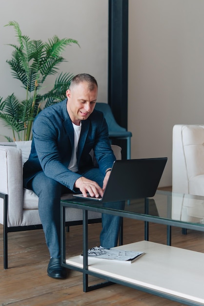 Homme d'affaires assis dans un bureau travaillant avec un ordinateur portable. Portrait d'homme d'affaires.