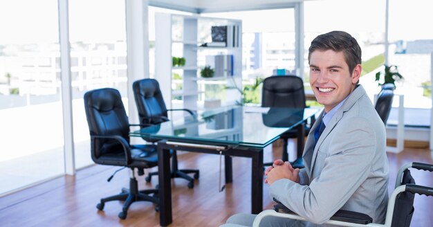 Homme d'affaires assis sur un fauteuil roulant au bureau