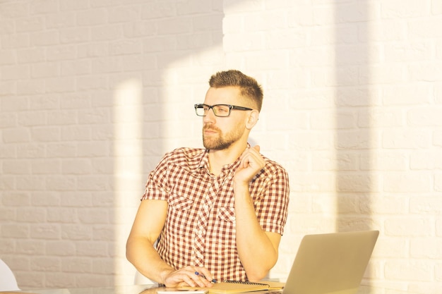 Homme d'affaires au bureau avec ordinateur portable et bloc-notes