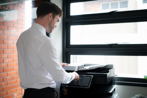 Homme d'affaires au bureau travaillant avec une photocopieuse