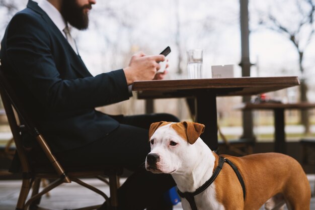 Homme d'affaires au café avec chien. Meilleurs amis au café.