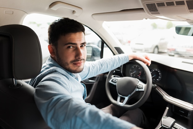 Homme d'affaires au volant d'une voiture de luxe