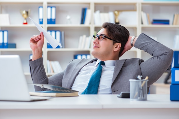 Homme d'affaires avec avion en papier au bureau