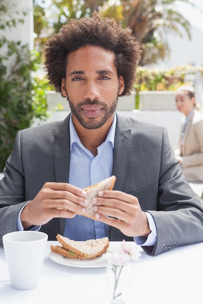 Homme d&#39;affaires ayant un sandwich pour le déjeuner