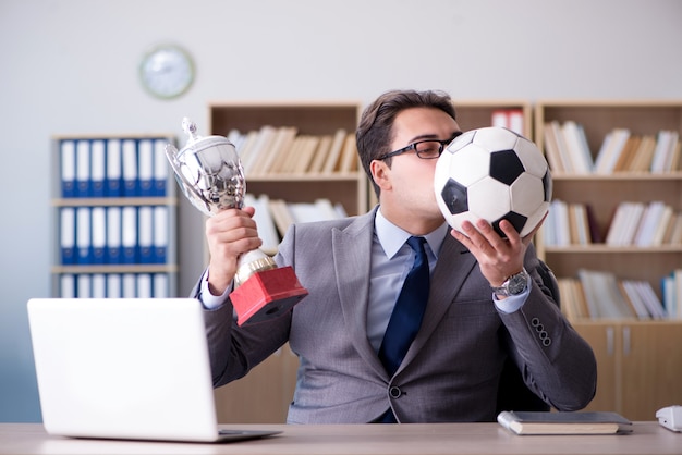 Homme d'affaires avec ballon de football au bureau
