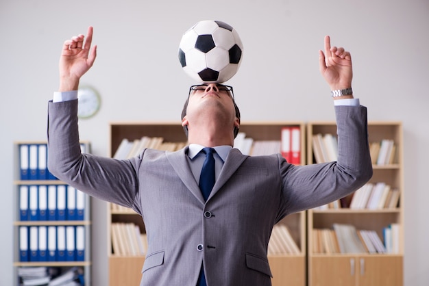 Homme d'affaires avec ballon de football au bureau