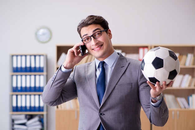 Homme d'affaires avec ballon de football au bureau