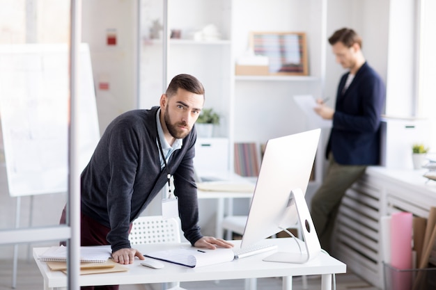 Homme d'affaires barbu debout au bureau