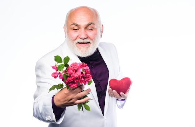 Homme d'affaires barbu insuffisance cardiaque heureux homme mûr tenir des fleurs et du coeur amour et romance anniversaire et saint valentin greffe de donneur problèmes de traitement de santé avec le coeur vous devriez essayer