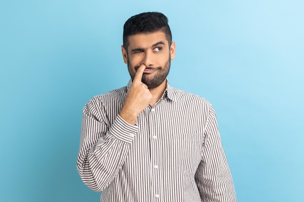 Homme d'affaires barbu mettant un doigt dans son nez en s'amusant avec de mauvaises habitudes comportement irrespectueux