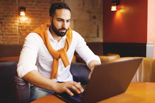 Homme d'affaires barbu multiculturel travaillant au café