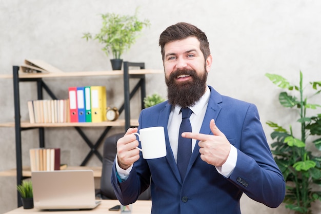 Homme d'affaires barbu tenir fond de bureau de support de tasse de café. Les gens qui réussissent boivent du café. Boire du café pause détente. Patron profitant d'une boisson énergisante. Accro à la caféine. Commencez la journée avec du café.