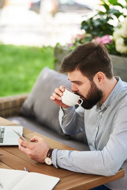 Homme d'affaires barbu travaillant dans le café