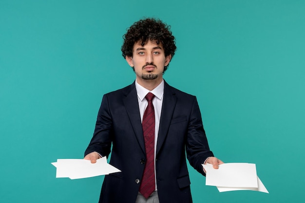 Homme d'affaires beau jeune homme mignon en costume noir et cravate rouge manipulant des feuilles de papier