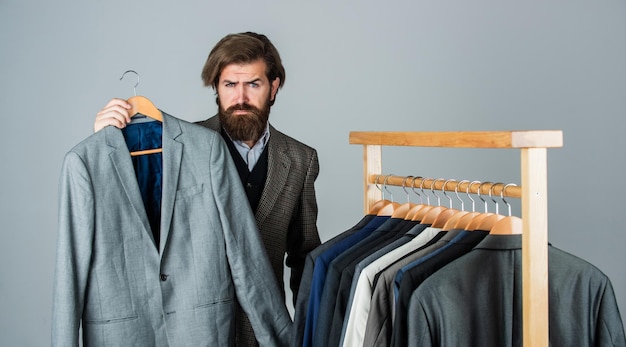 Homme d'affaires beau mec dans un magasin de vêtements en choisissant le concept de costume classique de vêtements