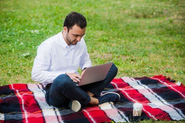 Homme d'affaires bien pensé dans le domaine. Avec ordinateur portable