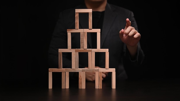 Homme d'affaires avec bloc de bois et toucher ou pointer vers quelque chose. Stratégie d'entreprise et concept de développement.