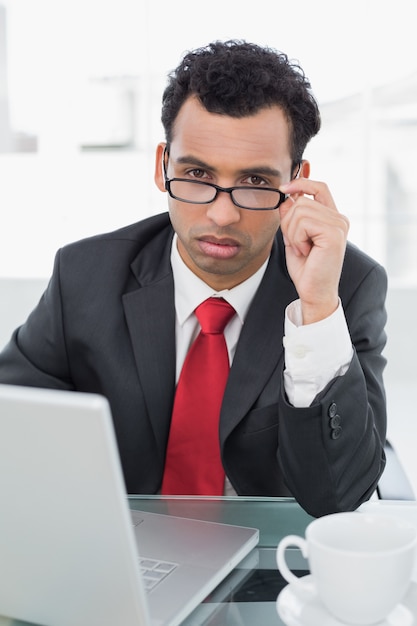 Homme d&#39;affaires bouleversé avec ordinateur portable assis au bureau