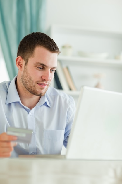 Homme d&#39;affaires avec carte de crédit et ordinateur portable dans son homeoffice