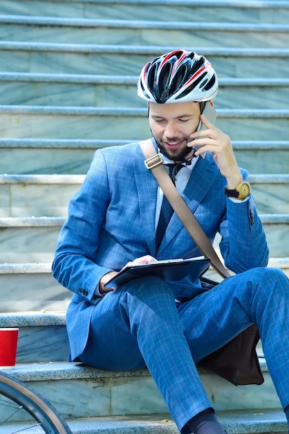 Un homme d'affaires avec un casque assis sur les escaliers.