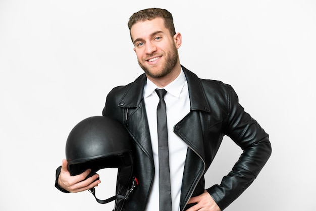 Homme d'affaires avec un casque de moto sur fond blanc isolé posant avec les bras à la hanche et souriant