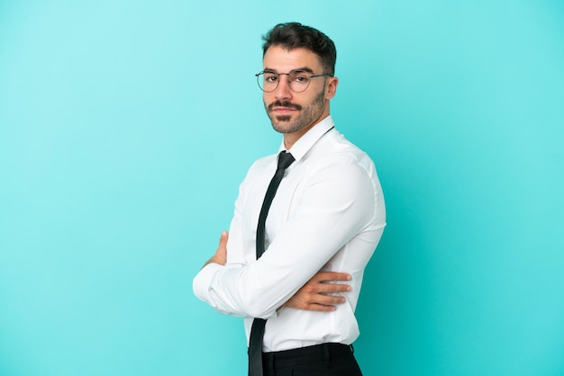 Homme d'affaires caucasien isolé sur fond bleu avec les bras croisés et impatient