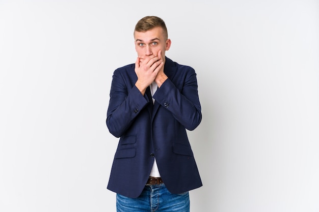 Homme d'affaires caucasien jeune choqué couvrant la bouche avec les mains.