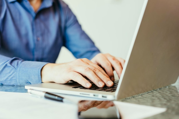 Homme d'affaires avec chemise bleue assis à son lieu de travail au bureau