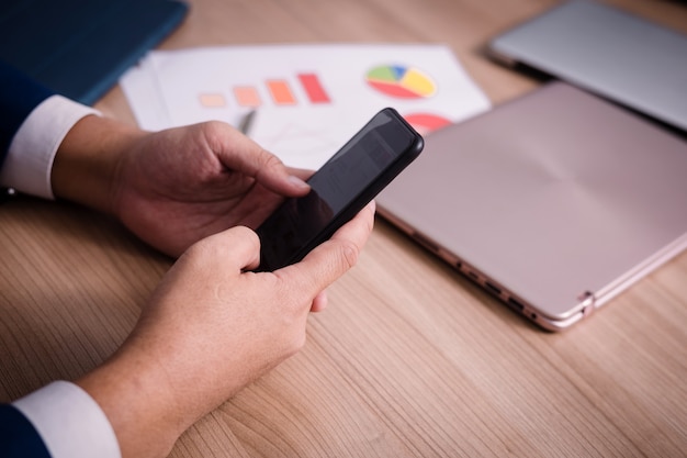 Homme d&#39;affaires cherchant des données avec un smartphone entre la réunion de brainstorming