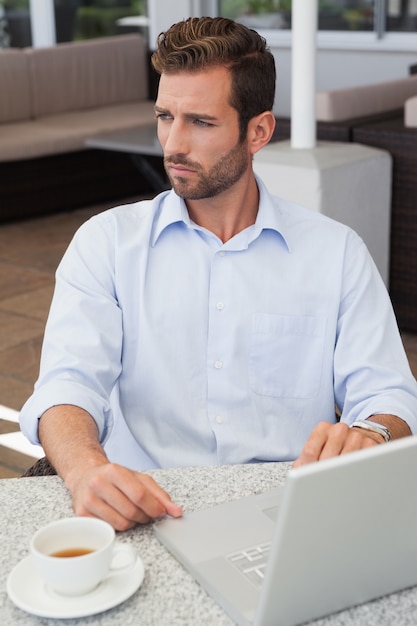 Homme d&#39;affaires ciblé travaillant avec ordinateur portable à table