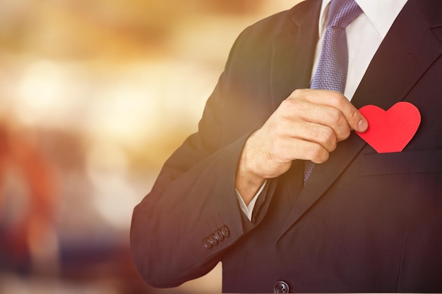 Homme d'affaires avec coeur rouge sur la poitrine gauche avec un tracé de détourage.