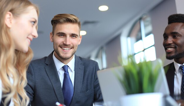 Homme d'affaires avec des collègues en arrière-plan au bureau.