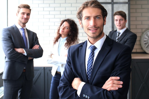 Homme d'affaires avec des collègues en arrière-plan au bureau