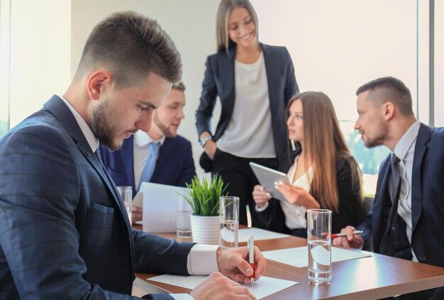 Homme d'affaires avec des collègues en arrière-plan au bureau